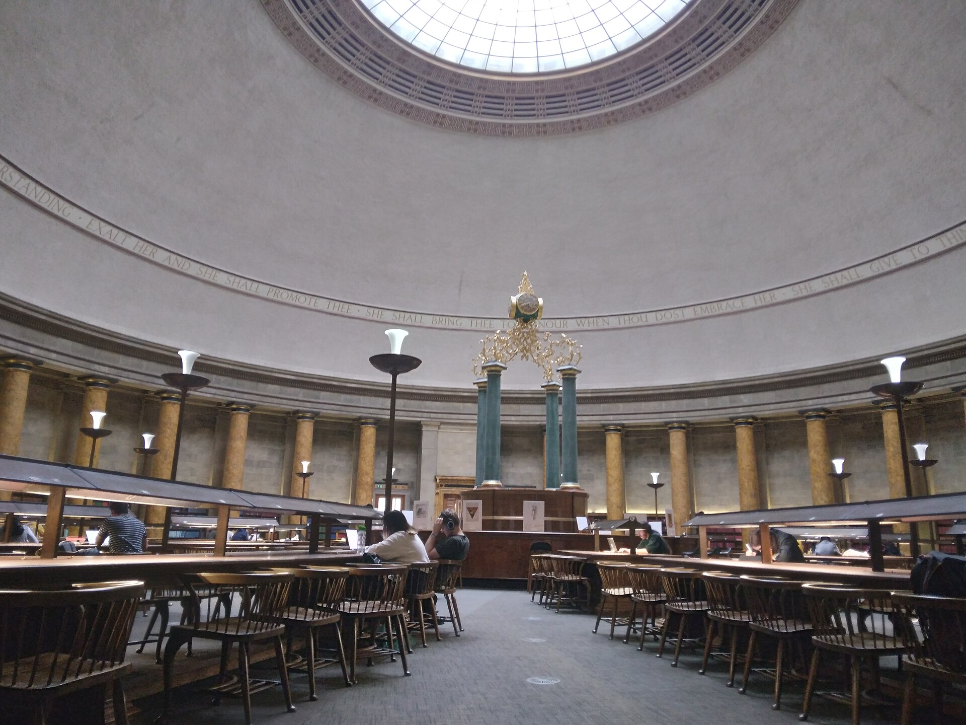 Czytelnia publicznej biblioteki miejskiej w Manchesterze — ludzie uczą się przy stołach pod zabytkowym sklepieniem