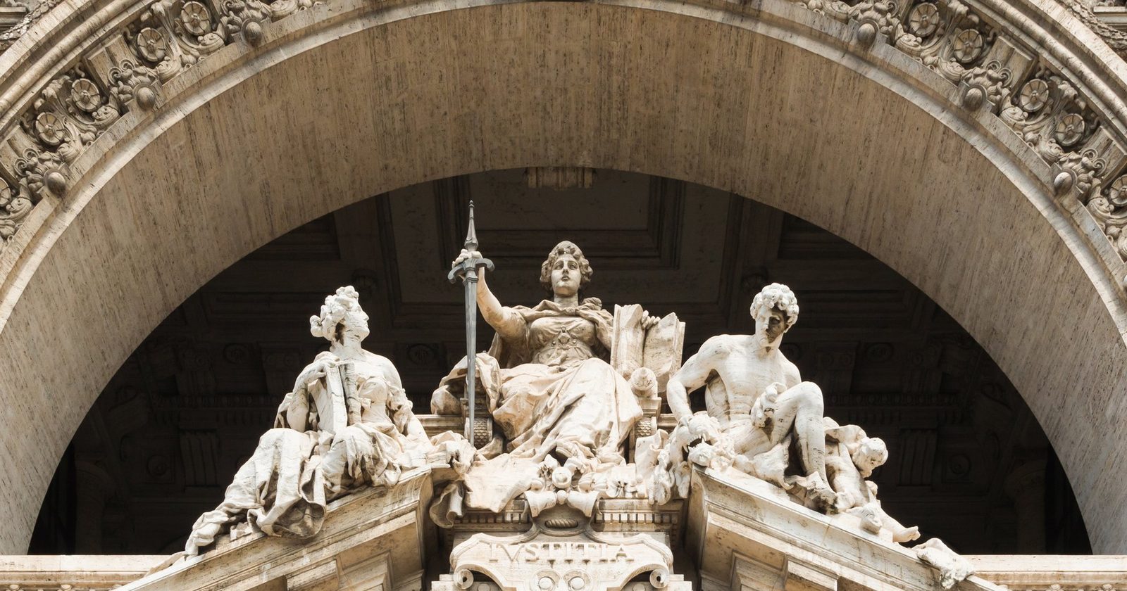 Rzeźba Temidy (Iustitia) z mieczem na fasadzie Pałacu Sprawiedliwości w Rzymie — symbol sprawiedliwości podatkowej